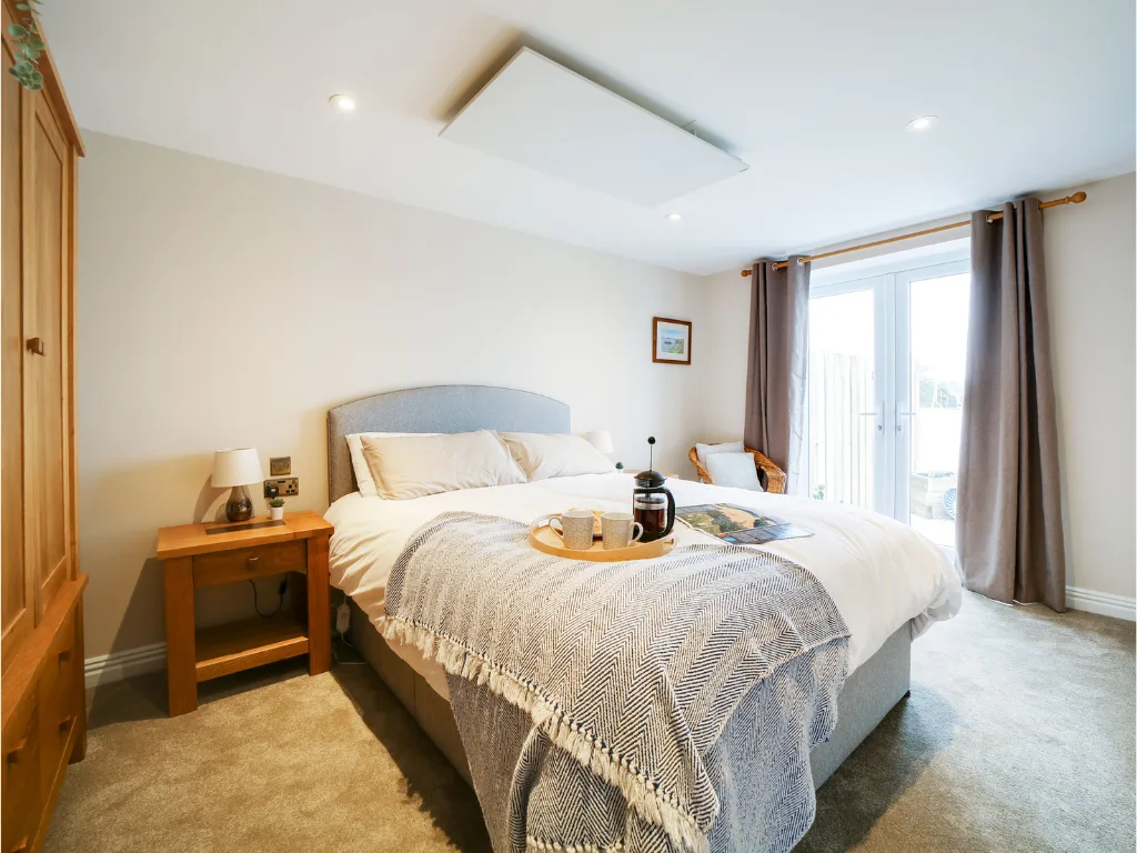 Tractor Shed bedroom. King-size bed dressed in white linen with a throw and breakfast tray.