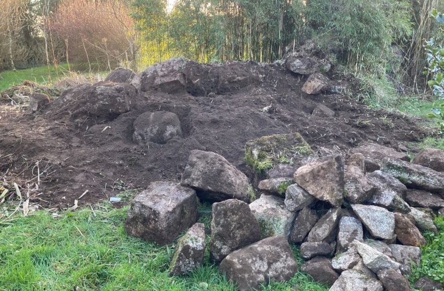 A pile of stones and dug-up soil in the garden at Trewena Cottages.
