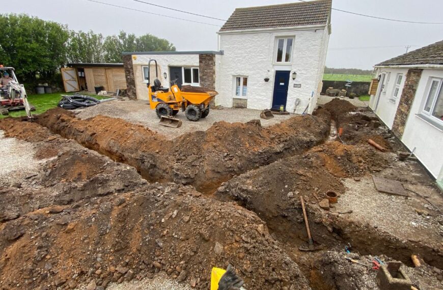 Heavy machinery digging trenches for utilities at Trewena Cottages.