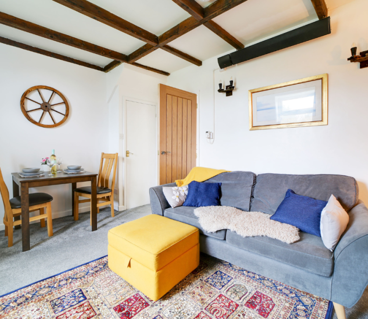 Open living and dining area in Little Avalon cottage with exposed beams and a cosy atmosphere.